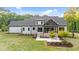 An expansive backyard showcasing a stone fire pit, covered porch, and professional landscaping enhance this property's charm at 15517 Possum Track Rd, Raleigh, NC 27614
