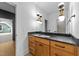 Bathroom with wood cabinets, black countertop, and unique lighting fixtures at 15517 Possum Track Rd, Raleigh, NC 27614