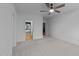 Carpeted bedroom with a ceiling fan, two windows, and en-suite bathroom at 15517 Possum Track Rd, Raleigh, NC 27614