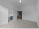 Spacious bedroom with neutral carpeting and doorways leading to an en-suite bathroom and a separate room at 15517 Possum Track Rd, Raleigh, NC 27614