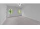 Bright and airy bedroom with two large windows offering natural light and a view of the surrounding greenery at 15517 Possum Track Rd, Raleigh, NC 27614