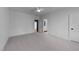 Minimalist bedroom featuring neutral carpeting, a ceiling fan, and doorways leading to other rooms at 15517 Possum Track Rd, Raleigh, NC 27614