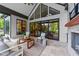 Relaxing covered outdoor patio with stone fireplace and comfortable seating featuring a view to the backyard at 15517 Possum Track Rd, Raleigh, NC 27614