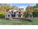 Beautiful exterior elevation of a stone home on a lush, green lot with mature landscaping at 15517 Possum Track Rd, Raleigh, NC 27614