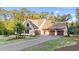 Charming home exterior featuring a three-car garage, manicured lawn, tasteful landscaping, and elegant facade at 15517 Possum Track Rd, Raleigh, NC 27614