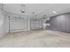 Spacious three-car garage with bright lighting, concrete floors, overhead storage and large gray storage cabinets at 15517 Possum Track Rd, Raleigh, NC 27614