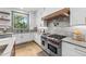 Gourmet kitchen featuring stainless steel range, white cabinetry, and elegant countertops at 15517 Possum Track Rd, Raleigh, NC 27614