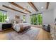 Spacious bedroom featuring exposed beams, large windows, and stylish furnishings at 15517 Possum Track Rd, Raleigh, NC 27614