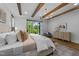 Bright primary bedroom featuring exposed beams, large windows, and stylish furnishings at 15517 Possum Track Rd, Raleigh, NC 27614