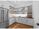 Walk-in pantry with custom shelving, stainless steel refrigerator, and ample storage space at 15517 Possum Track Rd, Raleigh, NC 27614