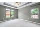 Calm bedroom featuring neutral walls, carpet, and windows overlooking landscaped yard at 1604 Vineyard Mist Dr, Cary, NC 27519