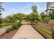 Scenic community pathway lined with flowering trees and split rail fence under a blue sky at 1604 Vineyard Mist Dr, Cary, NC 27519