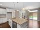 Open-concept kitchen features an island, stainless steel appliances, and seamless flow to living area at 1604 Vineyard Mist Dr, Cary, NC 27519