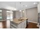 Open-concept kitchen features an island, stainless steel appliances, and seamless flow to living area at 1604 Vineyard Mist Dr, Cary, NC 27519