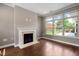 Cozy living room featuring hardwood floors, a fireplace, and large windows overlooking the yard at 1604 Vineyard Mist Dr, Cary, NC 27519
