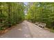 Serene walking path lined with lush trees and park benches, perfect for a quiet stroll at 1604 Vineyard Mist Dr, Cary, NC 27519