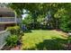 Expansive backyard featuring lush green grass, mature trees, and partial home view at 1700 St Marys St, Raleigh, NC 27608