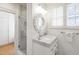 Bright bathroom with a marble top vanity, glass enclosed shower and classic white tile at 1700 St Marys St, Raleigh, NC 27608