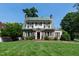 Stately home boasts an expansive lawn, brick accents, and a unique green tile roof at 1700 St Marys St, Raleigh, NC 27608