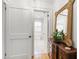 Hallway with rich wood floors, a decorative dresser and a view into a bright bedroom at 1700 St Marys St, Raleigh, NC 27608