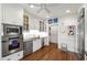 Well-equipped kitchen featuring white cabinetry, stainless steel appliances, and hardwood floors at 1700 St Marys St, Raleigh, NC 27608