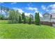 Expansive backyard featuring lush green grass and mature trees, offering a serene and private outdoor space at 1808 Pennypacker Ln, Durham, NC 27703