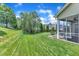 Beautifully landscaped backyard with lush green grass, mature trees, and an outdoor seating area at 1808 Pennypacker Ln, Durham, NC 27703