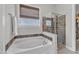 Bathroom featuring a shower, bath and window with a light-blocking shade at 1808 Pennypacker Ln, Durham, NC 27703