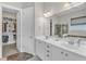 Bathroom featuring double sinks, white cabinets, and a view to the walk-in closet and shower at 1808 Pennypacker Ln, Durham, NC 27703