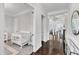 Bright Bedroom with a white crib and a view into the hallway with dark hardwood floors at 1808 Pennypacker Ln, Durham, NC 27703