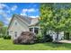 Landscaped yard with mature trees surrounding an attached two-car garage at 1808 Pennypacker Ln, Durham, NC 27703
