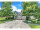 Attractive home featuring a well-kept lawn, mature trees, and a driveway leading to a two-car garage at 1808 Pennypacker Ln, Durham, NC 27703