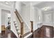Elegant hallway with dark hardwood floors, leading to a staircase and front entry with natural light at 1808 Pennypacker Ln, Durham, NC 27703