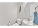 This is a neutral toned powder room with a pedestal sink and round mirror at 1808 Pennypacker Ln, Durham, NC 27703
