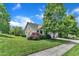 Spacious yard featuring mature trees, lush green grass, and an attached two-car garage at 1808 Pennypacker Ln, Durham, NC 27703
