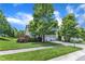 Expansive yard with mature trees, manicured lawn, and a view of the house with a two-car garage at 1808 Pennypacker Ln, Durham, NC 27703