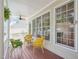 Back porch features bright windows, comfortable seating, and a ceiling fan at 1817 Wysong Ct, Raleigh, NC 27612