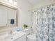 Clean bathroom featuring a shower-tub combo, neutral colors, and decorative mirror at 1817 Wysong Ct, Raleigh, NC 27612