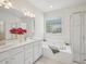 Bright bathroom with dual sinks, a jacuzzi tub, and glass-enclosed shower at 1817 Wysong Ct, Raleigh, NC 27612