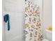 Bathroom features a shower with patterned curtain, a towel rack, and a toilet at 1817 Wysong Ct, Raleigh, NC 27612