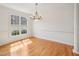 Sun-filled dining room with hardwood floors, bright light fixture, and large window at 1817 Wysong Ct, Raleigh, NC 27612