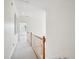 Upstairs hallway with white walls, neutral carpet, and railing to stairs at 1817 Wysong Ct, Raleigh, NC 27612