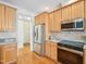 Eat-in kitchen boasts stainless appliances, granite counters, tile backsplash, and wood floors at 1817 Wysong Ct, Raleigh, NC 27612