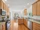Bright kitchen features granite countertops, wood cabinets, stainless steel appliances, and hardwood floors at 1817 Wysong Ct, Raleigh, NC 27612