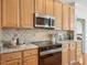 Charming kitchen features granite counters, stainless appliances, and tiled backsplash at 1817 Wysong Ct, Raleigh, NC 27612