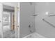Bathroom shower with white surround, shower head, and grab bar for accessibility at 1818 Cecil St, Durham, NC 27707