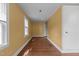 A well-lit room featuring hardwood floors, bright yellow walls, and a window with natural light at 1818 Cecil St, Durham, NC 27707