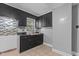 Classic kitchen with black cabinetry, stainless steel sink, tile backsplash, and tile flooring at 1818 Cecil St, Durham, NC 27707