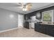 An angled view of a classic kitchen with dark cabinets, stainless steel sink, tile backsplash, and tile flooring at 1818 Cecil St, Durham, NC 27707