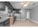A kitchen with black cabinets and a gray wall. It also has tile flooring and stainless steel appliances at 1818 Cecil St, Durham, NC 27707